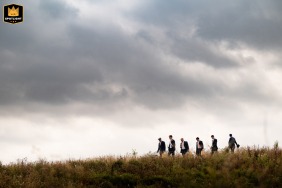 Groomsmen walking down a hill toward the ceremony at UK Wilderness Reserve.